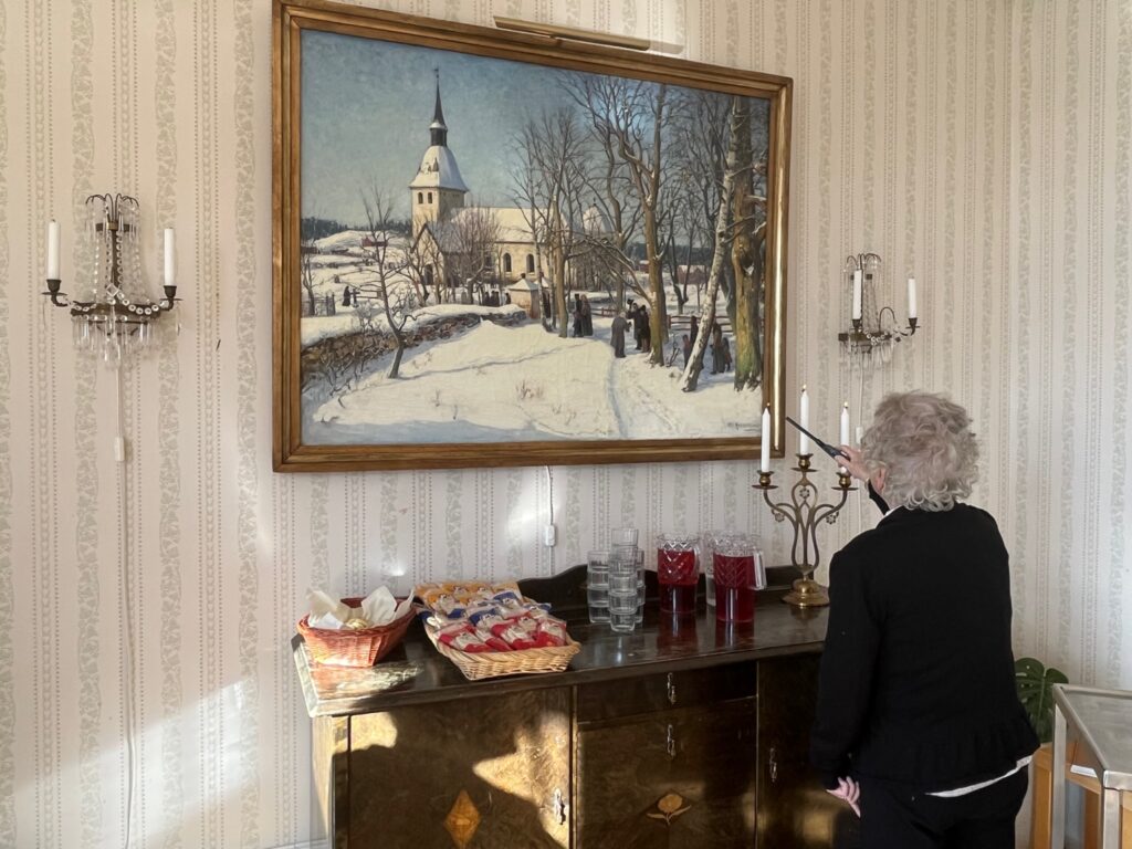 En av kaffevärdarna tänder ett ljus inne i prästgården.