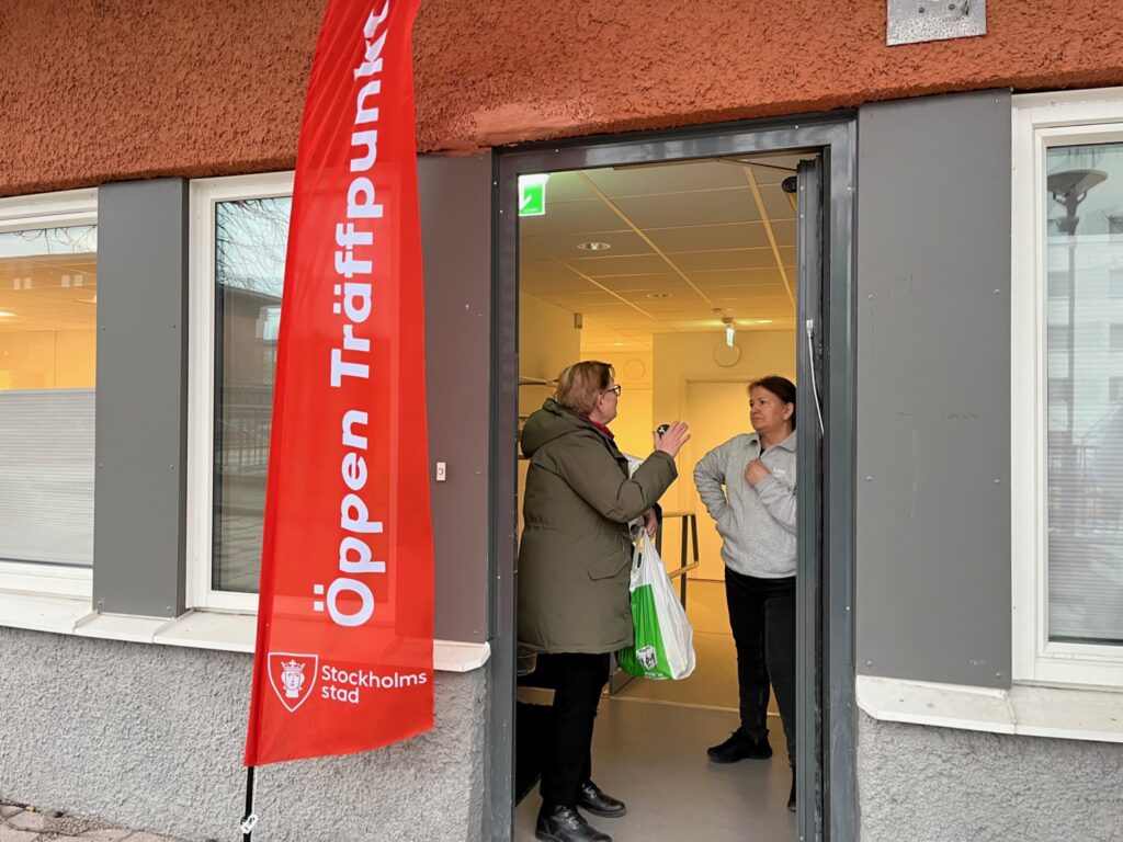 Två kvinnor pratar i dörröppningen till en lokal i Tensta.