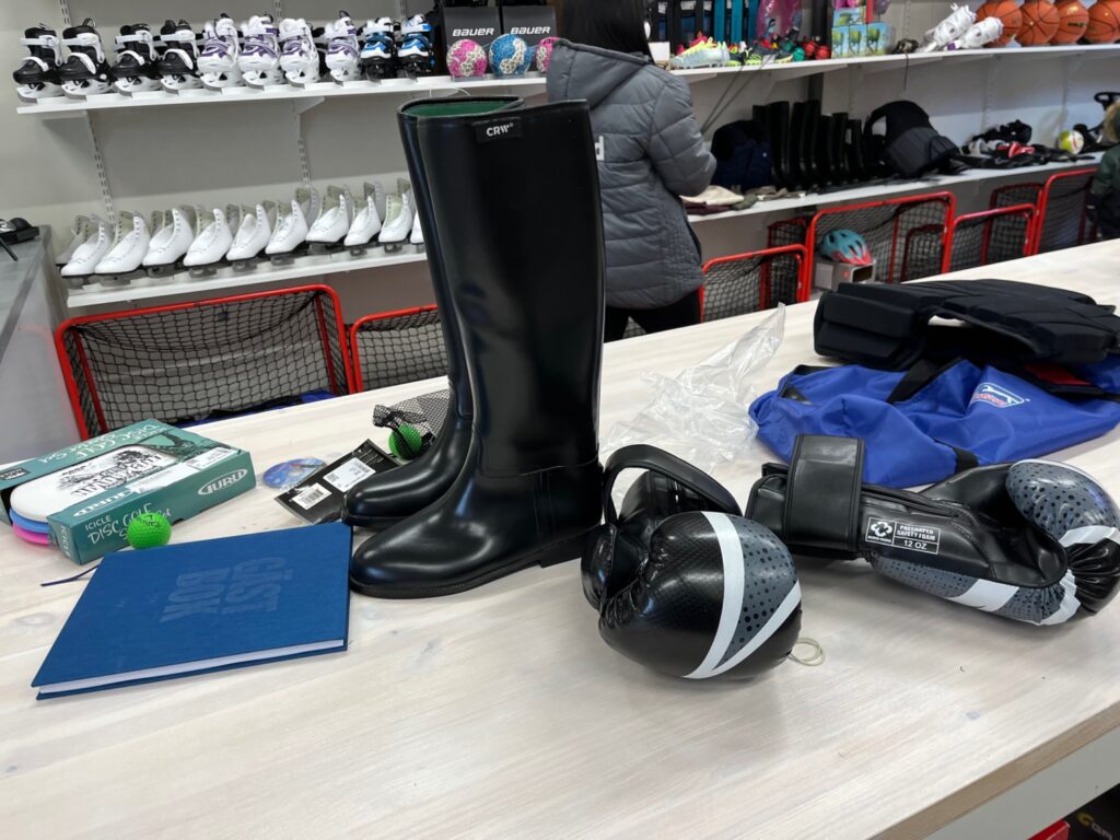 Närbild på ridstövlar och boxningshandskar.