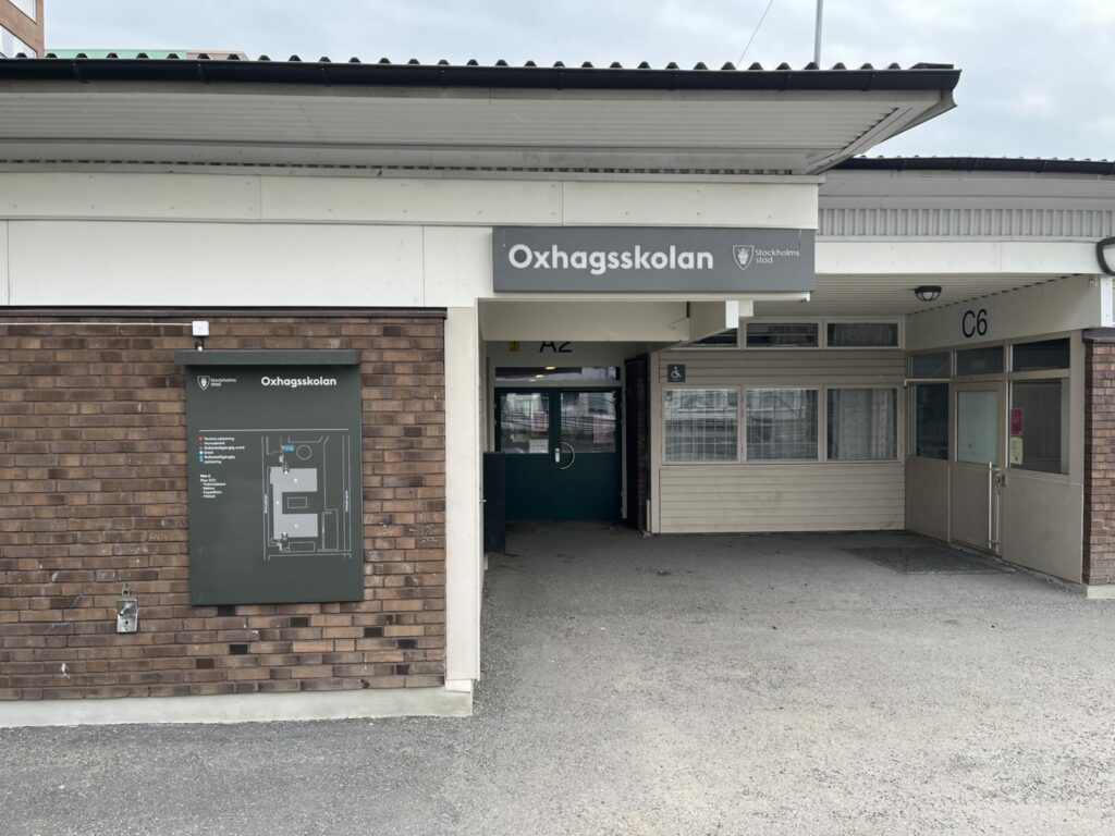 En skola på nära håll, skylten syns.