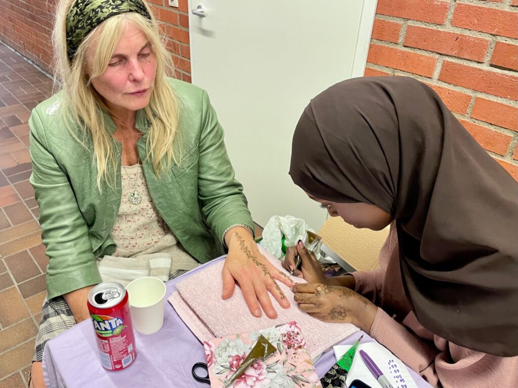 En kvinna får hennamålning på sin hand