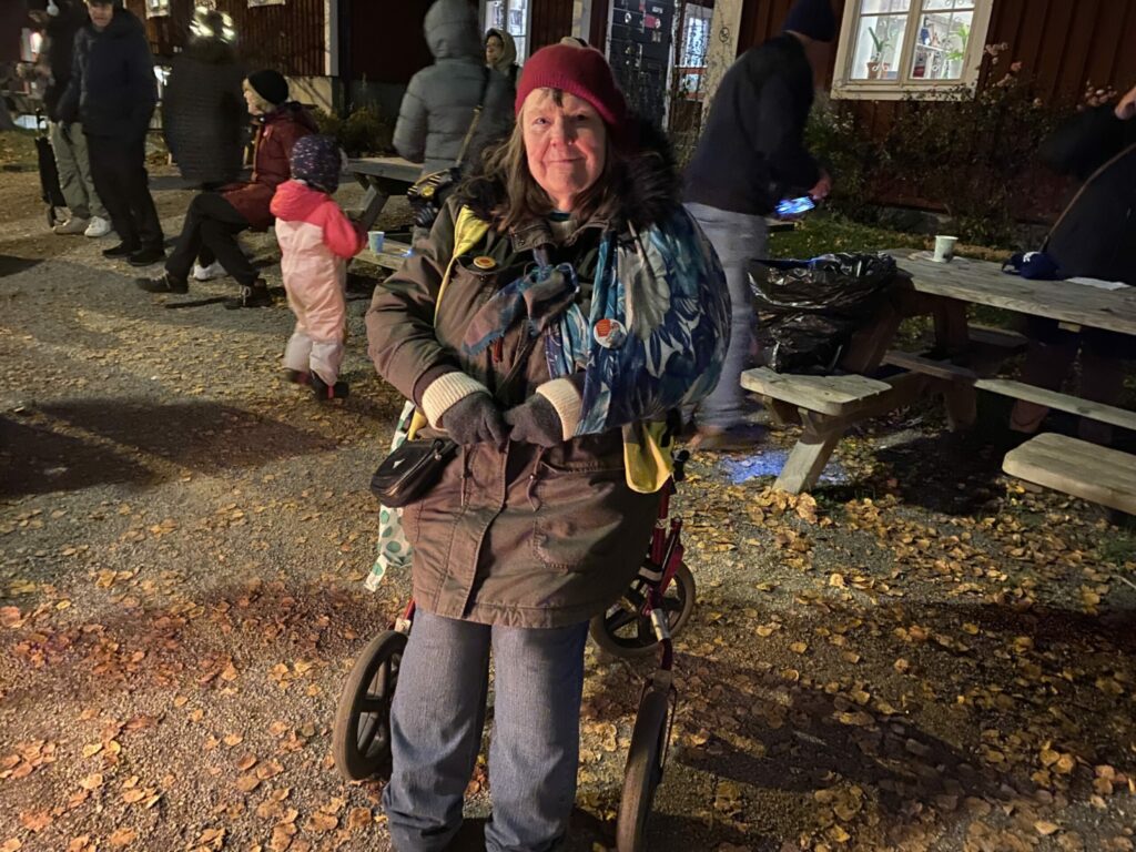 Dam som sitter på sin rollator och tittar in i kameran