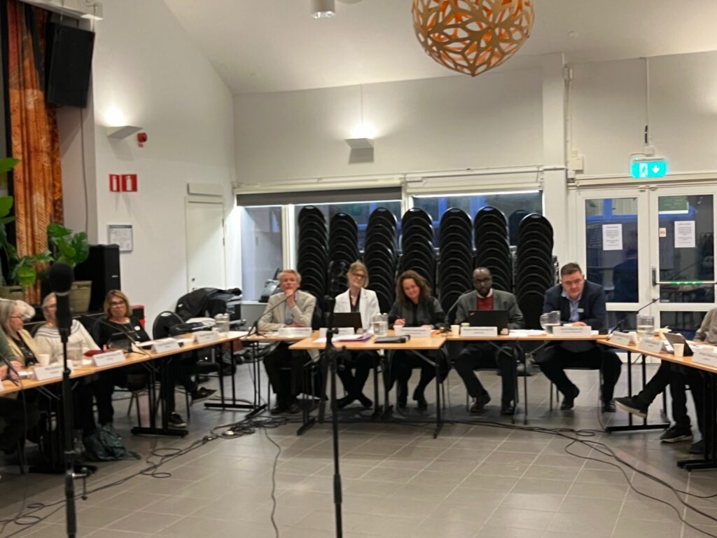 Några av politkerna och stadsdelsdirektören i podet på nämndmötet.