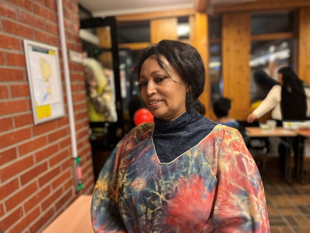 halvkroppsbild på finklädd kvinna i en föreningslokal